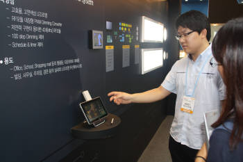 26일 일산 킨텍스 `국제 LED 엑스포`에서 금호전기 연구원이 RF를 이용한 조명 시스템을 설명하고 있다.