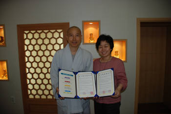 봉은사 총무-재무국장 진경스님(왼쪽)과 원광디지털대 사회복지학과장 이경욱 교수가 기념 촬영했다.