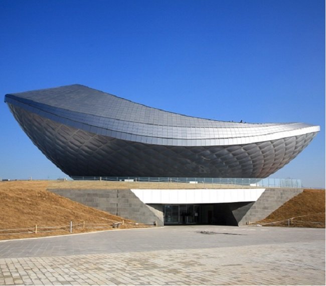 대구광역시 달성군에 위치한 디 아크(THE ARC, 건축가 하니 라시드 디자인). 잔잔한 물위에 돌을 튕겨 만드는 물수제비와 수면 위로 뛰어 오르는 물고기와 한국전통 도자기인 막사발을 표현