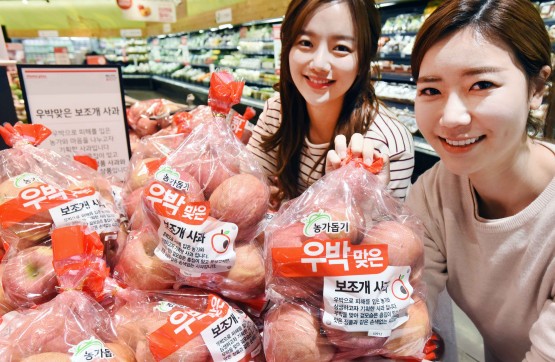 대형마트 업체들이 때 아닌 이색 과일 판매전을 펼치고 있다. 홈플러스 강서점에서 모델들이 ‘우박맞은 보조개 사과’를 선보이고 있다. 사진=홈플러스 제공
