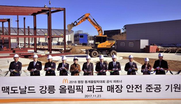 2018 평창 동계올림픽대회 공식 파트너인 맥도날드는 지난 23일, 강원도 강릉에서 동계올림픽 기념 매장인 ‘강릉 올림픽 파크 매장’의 안전 준공 기원식을 진행했다. 한국맥도날드 조주연 사장(가운데), 김장미 강릉 올림픽 파크 매장 점장, 매장 건축 및 운영 담당 임직원, 시공사 및 협력사 대표 등이 햄버거 모양 매장이 들어설 둥근 부지 위에서 안전 준공 기원 리본커팅을 진행하고 있다. 사진=한국맥도날드 제공
