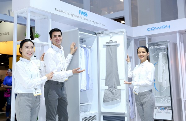 코웨이 모델들이 ‘2018 CES(Consumer Electronics Show)’에서 최초 선보이는 ‘코웨이 의류청정기 FWSS(Fresh Wear Styling System)’을 소개하고 있다. 사진=코웨이 제공