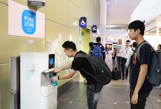 말레이시아 쿠알라룸푸르국제공항(Kuala Lumpur International Airport) 내 코웨이 정수기를 체험할 수 있는 'Pure Zone'에서 공항 이용객들이 코웨이 정수기로 정수한 깨끗한 물을 마시고 있다. 사진=코웨이 제공