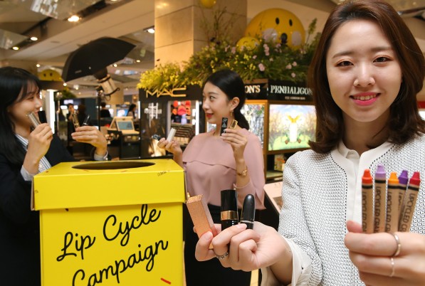현대백화점 압구정본점에 비치된 립스틱 수거함 앞에서 직원들이 '립사이클 캠페인'을 소개하고 있다. 사진=현대백화점 제공