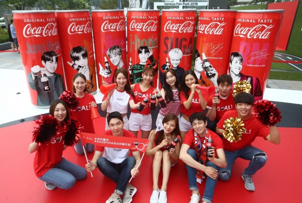 17일 오전, 서울 삼성동 코엑스 동편광장에 위치한 팬파크빌리지 내 ‘코카콜라 2018 FIFA 러시아월드컵 체험공간’에서 소비자모델들이 코카콜라 방탄소년단 스페셜 패키지를 배경으로 빌보드 1위를 기록했던 방탄소년단의 짜릿한 1위 DNA를 전하며 대한민국 대표팀의 선전을 기원하고 있다. 사진=코카콜라 제공