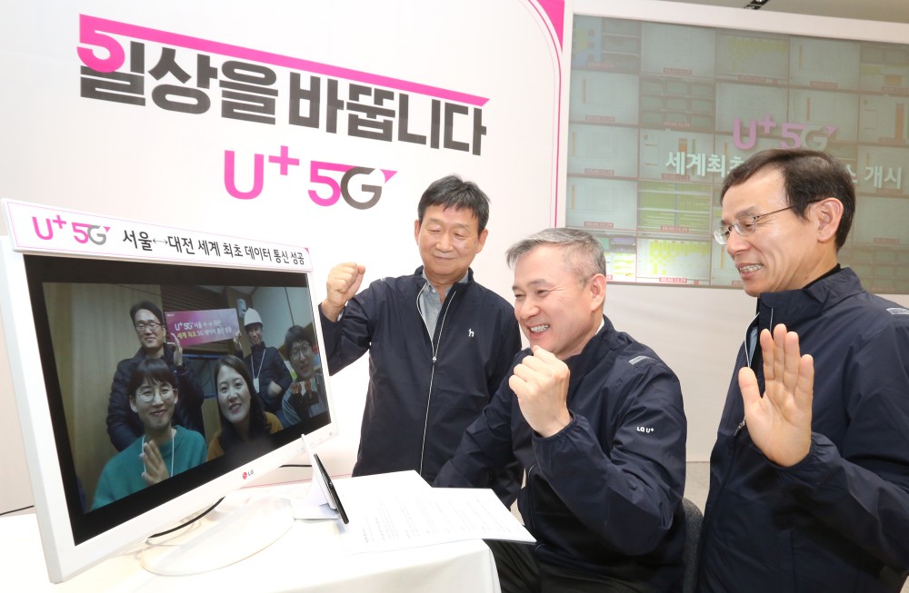 LG유플러스 하현회 부회장(가운데)이 대전기술원에서 서울 마곡 사옥에 5G망으로 걸려온 ‘화상통화’를 직접 받고, 상용 네트워크 서비스의 안정성을 확인하는 모습. 왼쪽부터 PS부문장 황현식 부사장, 하현회 부회장, 기업부문장 최주식 부사장