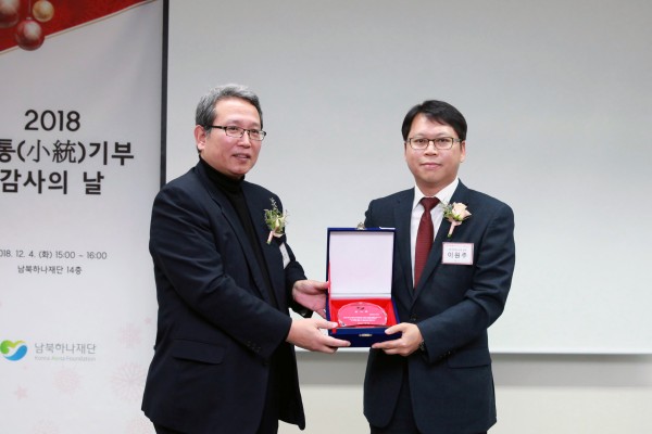 남북하나재단 고경표이사(왼쪽)가 NS홈쇼핑 사회공헌위원장 이원주 상무(오른쪽)에 감사패를 전달하고 기념촬영을 하고있다