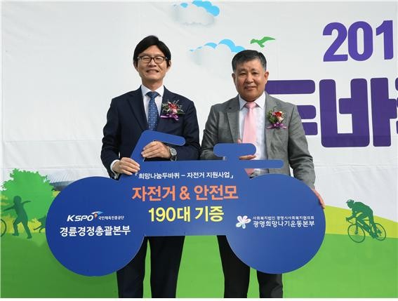 정병찬 경륜경정총괄본부장(왼쪽)이 이상재 광명시 사회복지협의회 회장에게 자전거와 안전모를 전달하고 있다.