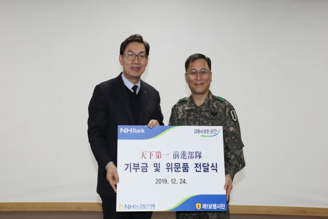 농협은행이 제1보병사단을 격려 방문하고 위문품을 전달했다. 이대훈 농협은행장(왼쪽)과 제1보병사단 김홍석 사단장이 기념촬영을 하고 있다.