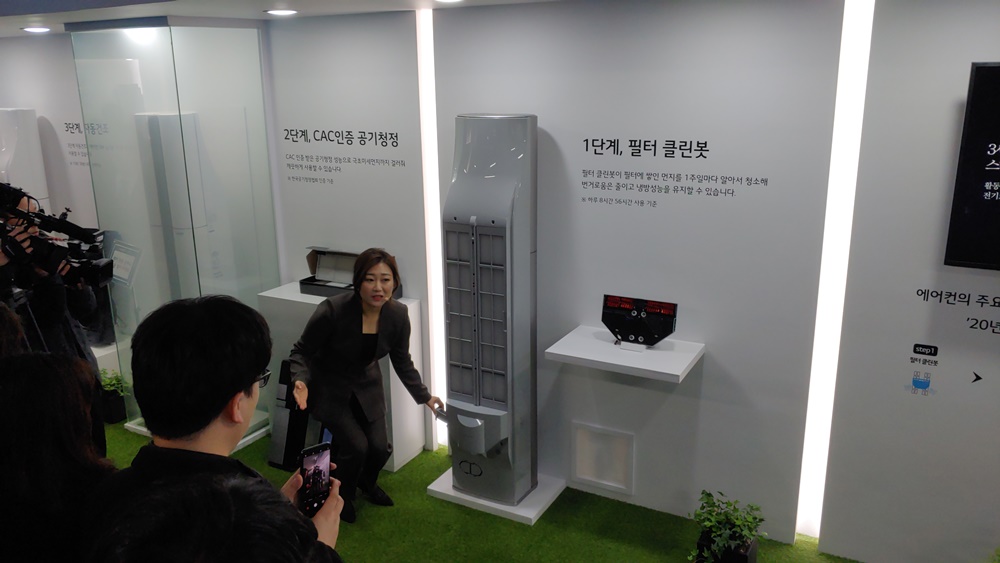 LG전자가 2020년형 휘센 에어컨 씽큐에 탑재된 1단계 필터 클린봇을 소개하고 있다. 필터 클린봇은 마치 로봇청소기 헤드 부분을 에어컨 필터 뒷면에 달아놓은 느낌이다.