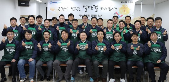 김인규 하이트진로 사장(맨앞줄 왼쪽에서 다섯번째)을 비롯한 임직원 30여명이 23일 서울역 인근 무료급식소 '따스한 채움터'에서 노숙인들에게 배식 봉사 후 기념촬영을 하고 있다. 출처=하이트진로