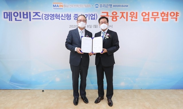 우리은행이 메인비즈협회와 금융지원 업무협약을 맺고 있다.박완식 우리은행 중소기업그룹장(오른쪽)과 석용찬 메인비즈협회장이 기념촬영을 하고 있다.