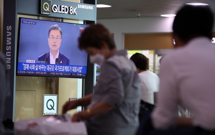 14일 오후 서울 용산구 서울역 대합실에서 시민들이 문재인 대통령의 한국판 뉴딜 국민보고대회 생방송을 시청하고 있다(제공:News1)