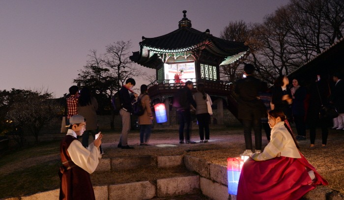 지난 창덕궁 달빛기행 참가자들이 청사초롱을 들고 거닐며 고궁의 고즈넉한 야간 풍경을 즐기고 있는 모습(제공:News1)