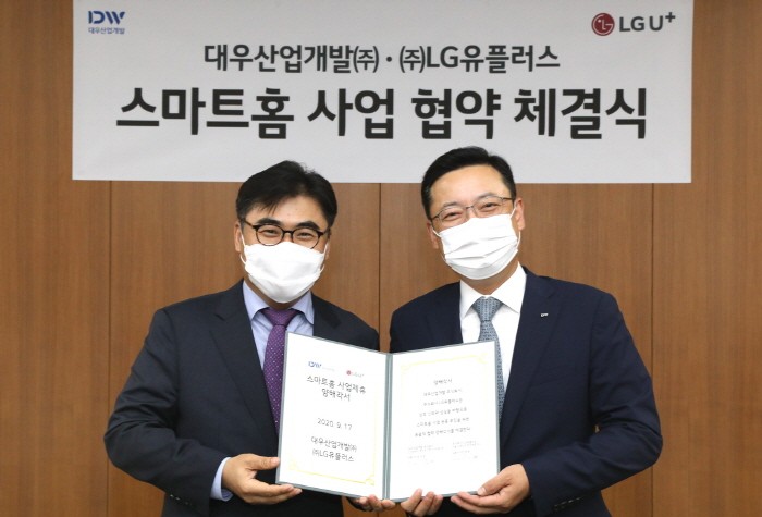 고재석 LG유플러스 홈영업담당(좌측)와 조재현 대우산업개발 상품외주담당 상무(우측)가 스마트홈 플랫폼 구축을 위한 업무협약 체결 후 기념촬영을 하고 있다. 사진 = LG유플러스