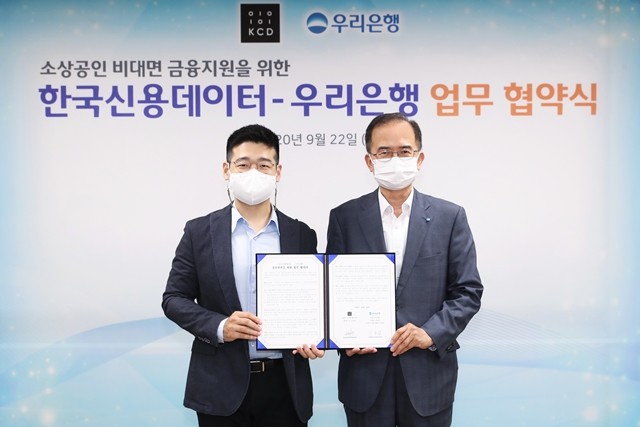 우리은행이 한국신용데이터와 소상공인 비대면 금융지원 업무협약을 맺었다. 서동립(오른쪽) 우리은행 중소기업그룹장과 김동호 한국신용데이터 대표가 기념 촬영을 하고 있다.