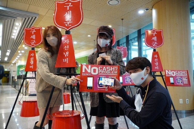 제로페이로 디지털 자선냄비에 QR코드 기부를 시연하고 있다.