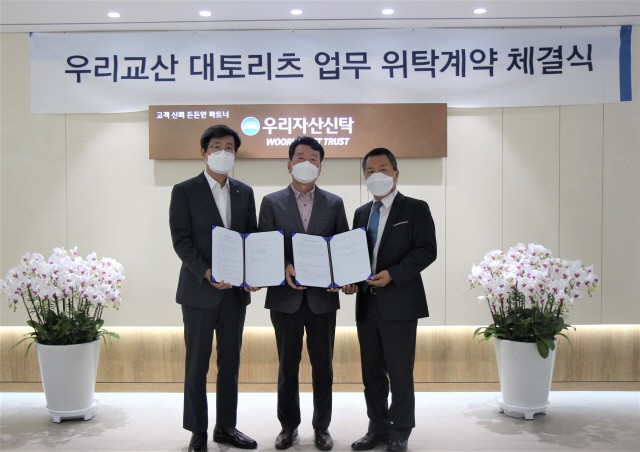 왼쪽부터 이창재 우리자산신탁 대표, 김흥태 (주)우리교산대토제1호리츠 대표, 한계현 교산홀딩스(주) 대표가 기념사진을 촬영하고 있다.