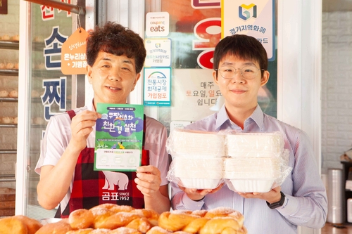 천지만나 박강석 대표(좌)와 쿠팡이츠서비스 담당자가 쿠팡이츠 친환경 포장 용기를 들고 사진을 촬영하고 있다. 사진=쿠팡.