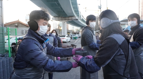 코스콤 임직원들이 영등포구 쪽방촌에 연탄을 배달하고 있다. 사진=코스콤.