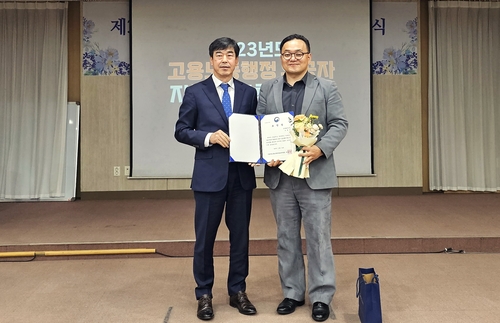 고용노동부 서울남부지청에서 열린 시상식에 참석한 롯데웰푸드 조윤근 비상안전매니저(우)과 고용노동부 정병진 서울남부지청장이 기념사진을 촬영하고 있다. 사진=롯데웰푸드.