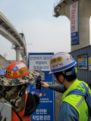 서울에 위치한 토목 현장에서 근로자가 전용 어플리케이션을 통해 작업 중지를 접수하고 있다. 사진=삼성물산.