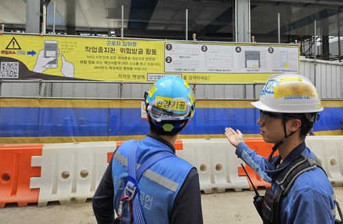 경기도에 위치한 한 건축현장에서 근로자들이 작업중지권 현수막을 확인하고 있다. 사진=삼성물산.