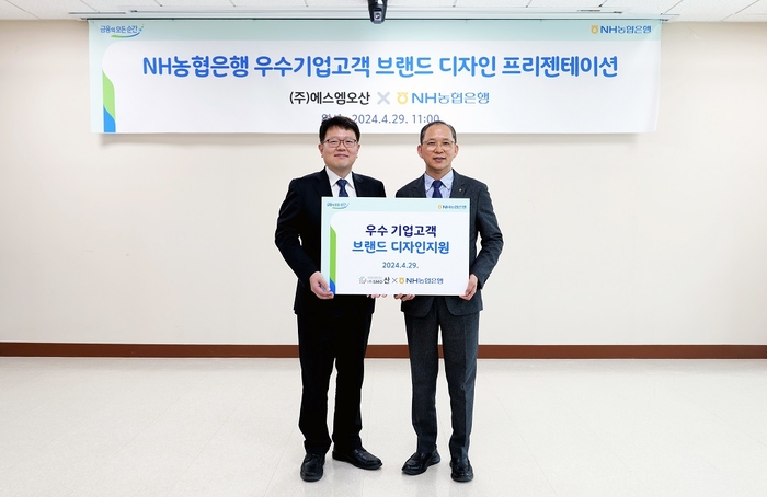 지난 29일 에스엠오산에서 진행된 브랜드디자인 지원 행사에서 박민규 에스엠오산 대표(좌)와 박병규 농협은행 수석부행장(우)이 기념촬영을 하고 있다. 사진=NH농협은행