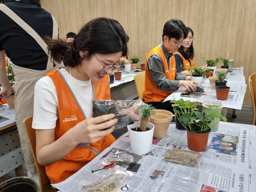 코스콤 임직원들이 본사 15층 강당에서 지역 소외이웃 대상 환경정화식물 기부를 위한 화분 식재 작업을 하고 있다. 사진=코스콤.