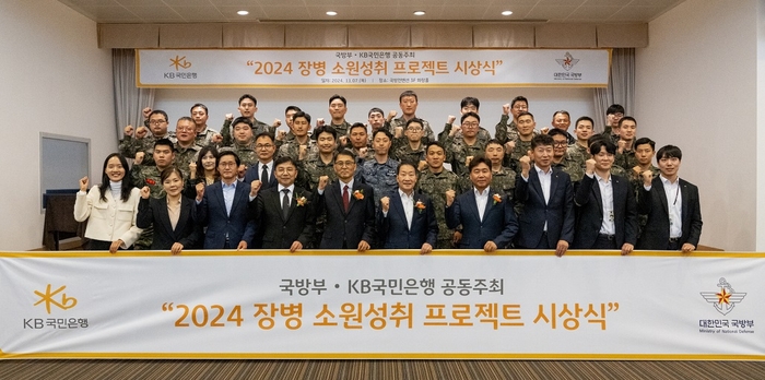 지난 7일 서울시 용산구에 위치한 국방컨벤션에서 열린 '2024 장병소원성취 프로젝트' 시상식에서 국방부 윤봉희 정책기획관(맨앞줄 좌측 5번째)과 KB국민은행 기관영업그룹 서영익 대표(맨앞줄 좌측 6번째)가 수상자들과 함께 기념촬영을 하고 있다. 사진=KB국민은행