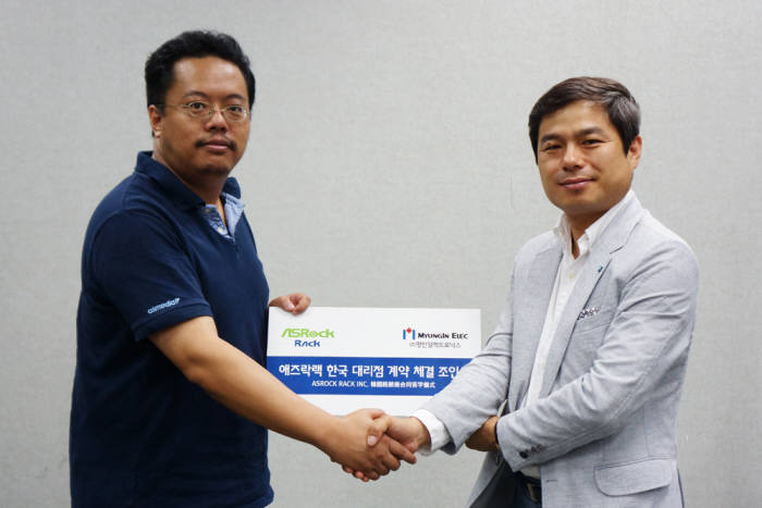 원용선 명인일렉트로닉스 대표(오른쪽)와 샤웨이쉬 애즈락랙 대표가 한국 대리점 계약을 체결하고 악수를 나누고 있다.
