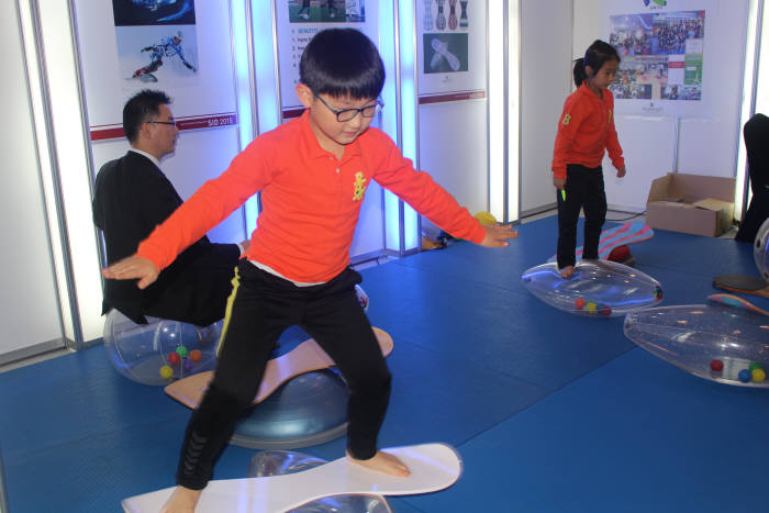 SID 2015에 참가한 네오피지오텍 재활스포츠시스템을 아이들이 체험하는 모습.