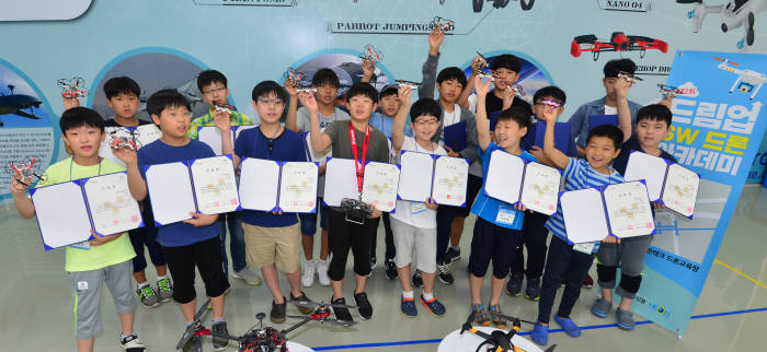 전자신문사가 주최한 '제2회 드림업 SW드론 아카데미' 수료식이 9일 경기도 안양시 평촌 네온테크 본사에서 열렸다. 수료생들이 소프트웨어(SW)를 배우며 만든 드론을 들고 파이팅을 외치고 있다.
김동욱기자 gphoto@etnews.com
