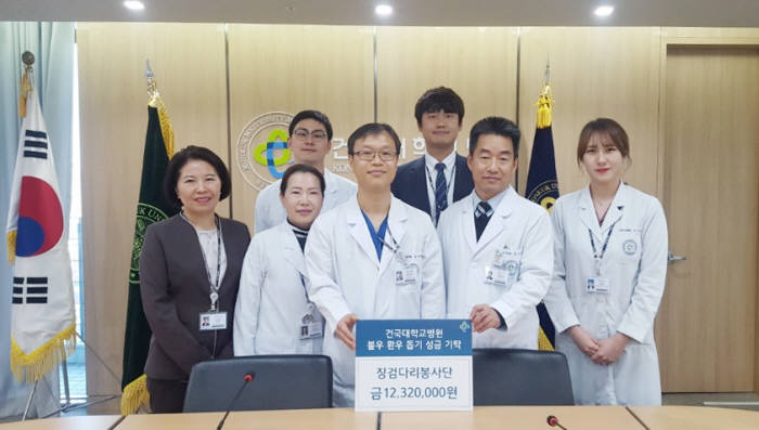건국대병원 징검다리 봉사단이 저소득층 환자에게 써달라며 1232만원을 병원측에 기부하고 기념촬영했다.