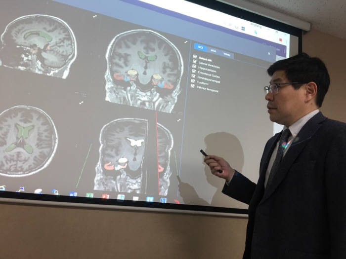 이건호 조선대 치매국책연구단장이 SW로 부위별 뇌위축 정도를 나타낸 화면을 보고 환자 상태를 설명하고 있다.
