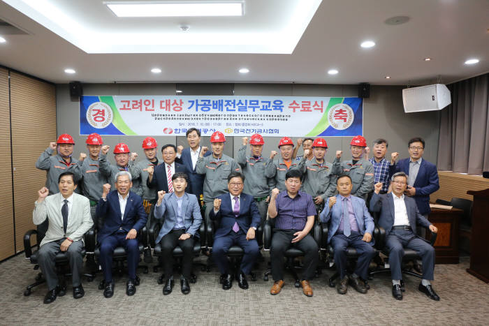류재선 전기공사협회 회장(앞줄 가운데)이 고려인 전기공사 기술자와 기념촬영했다.