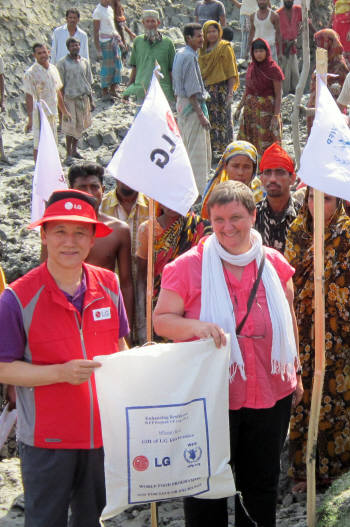 지난 8일 방글라데시 바리살 지역에서 LG김영기 부사장(왼쪽)이 WFP 방글라데시 사무소장 크리스타 라더에게 `LG희망가족을 위한 식량을 전달하고 있다.