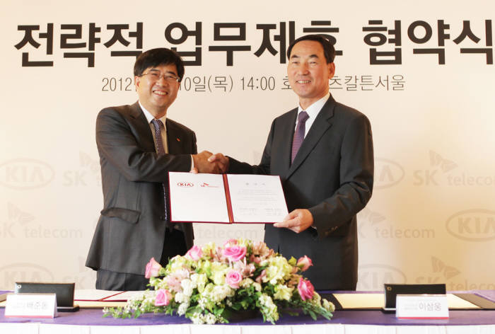 배준동 SK텔레콤 사업총괄(사진 왼쪽)과 이삼웅 기아자동차 사장이 `SK텔레콤과 기아자동차의 전략적 업무제휴 협약(MOU)` 체결 후 악수 하고 있다.