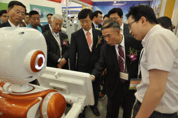 중국 정부 관계자들이 상하이 한국기계전시장을 방문해 스마트 로봇을 작동해보고 있다.