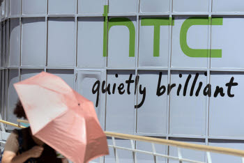 HTC 대만 본사 앞에서 한 여성이 우산을 쓰고 돌풍을 맞으며 지나가고 있다.