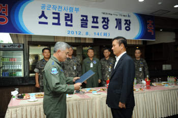 김영찬 골프존 사장(오른쪽)이 경기도 평택 공군부대에서 박신규 공군작전사령관에게 `골프존 비전 시설`을 기증한 후 개장식을 갖고 있다.