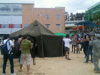 지난 8일 서울 신원초등학교에서 열린 `T24 소셜 페스티벌`에서 한 네티즌이 혼자 설치한 24인용 군용 텐트를 사람들이 바라보고 있다. 사진 출처. 국방부 트위터