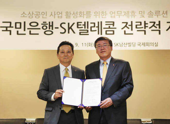 11일 SK텔레콤 남산사옥에서 박인식 SK텔레콤 기업사업부문장(오른쪽)과 이상원 KB국민은행 신성장사업그룹 부행장이 소상공인 사업 활성화를 위한 솔루션 사업 공동 추진 및 업무 제휴 등을 담은 MOU를 교환했다.