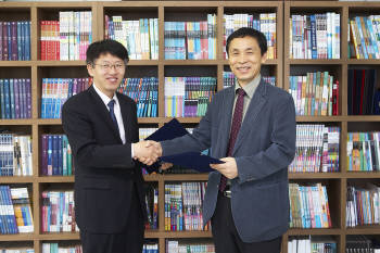 최대찬 비상교육 교재사업본부장과 강성주 한국교원대학교 교육연구원장이 업무협정후 악수를 나누고 있다.