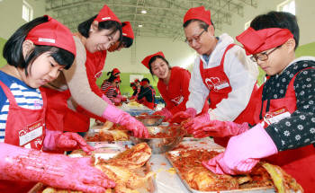 민원식 위니아만도 대표(오른쪽 두번째)가 꿈나무 마을 학생, 딤채클럽 회원들과 함께 김치를 담그고 있다.