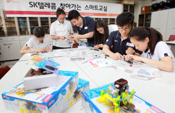 지난 7월 10일 의정부 경민여자중학교에서 실시된 ICT 과학교실에서 학생들이 SK텔레콤 전문 재능 봉사자의 도움을 받아 전자기 유도 현상 실험을 하고 있다