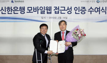 이병도 신한은행 미래채널본부장(오른쪽)과 이범재 웹와치 대표가 영등포구 신길동 소재 (사)한국장애인인권포럼에서 모바일 웹 접근성 인증식 후 인증서를 맞들고 있다