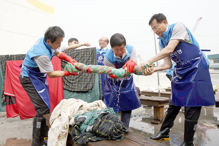 서울 구로구 가리봉동에 위치한 사단법인 지구촌사랑나눔에서 임원자원봉사 활동으로 신한은행 부행장 및 본부장들이 이불빨래를 하고 있다