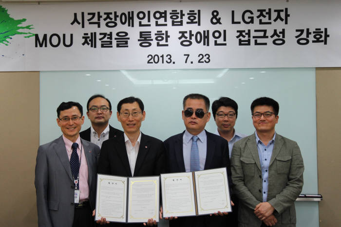 김홍배 LG전자 제품시험연구소장과 정성수 한국시각장애인연합회 상임이사(앞줄 왼쪽 두 번째부터)가 업무협약을 체결한 후 기념촬영했다.