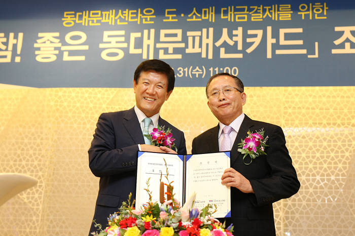 조준희 기업은행장(왼쪽)과 임정부 (사)동대문패션상인연합회장이 카드 조인식 후 악수를 나누고 있다